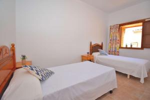 - une chambre avec 2 lits et une fenêtre dans l'établissement Casa Sa Raval 082 by Mallorca Charme, à Maria de la Salut