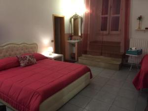 ターラントにあるB&B Il Tulipanoのベッドルーム1室(赤いベッド1台付)、バスルーム1室が備わります。