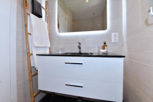 a white bathroom with a sink and a mirror at Les magnolias en Alsace - meublé de tourisme 3 étoiles in Barembach +55 photos
