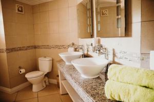 a bathroom with two sinks and a toilet and a mirror at Bay Gardens Beach Resort & Spa in Gros Islet