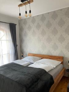 a bedroom with a bed and a wall at Apartment Weingartenblick - Glanzerhof in Gamlitz