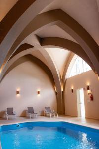 a swimming pool in a building with curved ceilings at Castelo Boutique Hotel in Fraiburgo