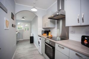 een keuken met witte kasten en een aanrecht bij Keithlands House By Horizon Stays in Stockton-on-Tees