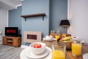 een woonkamer met een tafel met fruit en sinaasappelsap bij Keithlands House By Horizon Stays in Stockton-on-Tees