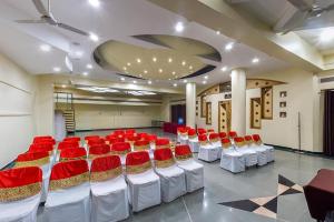 a large room with red and white chairs in it at Hotel City Park, Solapur in Solapur