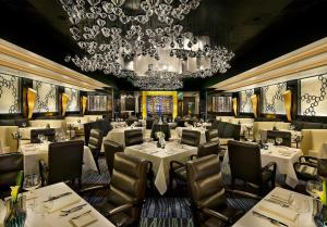 a restaurant with white tables and chairs and a chandelier at Atlantis Casino Resort Spa in Reno
