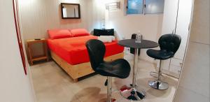 1 dormitorio pequeño con 1 cama, mesa y sillas en Departamentos Arrayanes en El Bolsón
