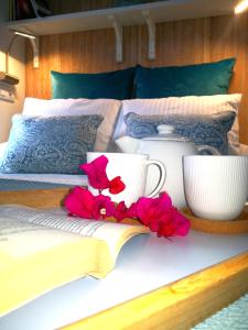 a bed with a book and cups and flowers on it at Blu Oceano in Teguise