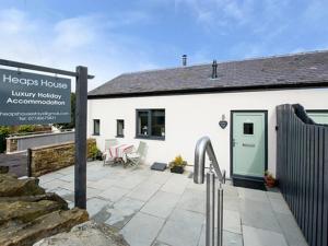 a white building with a sign in front of it at Heaps House in Denby Dale