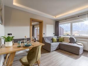 ein Wohnzimmer mit einem Sofa und einem Tisch in der Unterkunft Tirol Appartements Schwaiger in Niederndorf