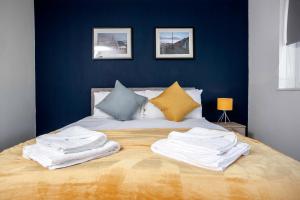 a bed with a bunch of towels on it at Hebburn House By Horizon Stays in Stockton-on-Tees