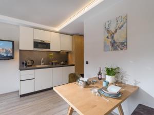 a kitchen with a wooden table in a room at Tirol Appartements Schwaiger in Niederndorf +30 photos