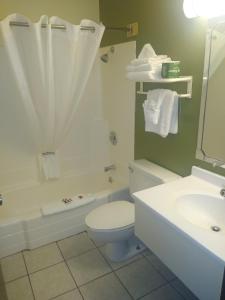 Super 8 by Wyndham Craig في كريج: حمام مع مرحاض وحوض استحمام ومغسلة