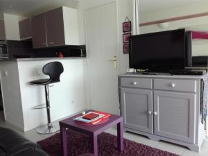 a living room with a tv on top of a cabinet at Location d Armelle - Moliets in Moliets-et-Maa