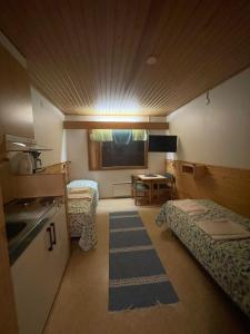 een kleine kamer met 2 bedden en een keuken bij Luppoloma in Saariselkä