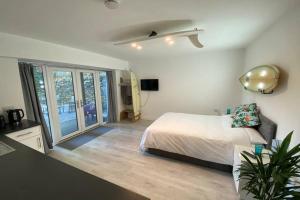 a bedroom with a bed and a large window at The Boardroom at The Beach House in Falmouth