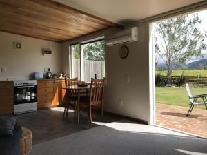 een keuken en eetkamer met een tafel en een raam bij Vineyard Cottage in Blenheim on the Golden Mile in Blenheim