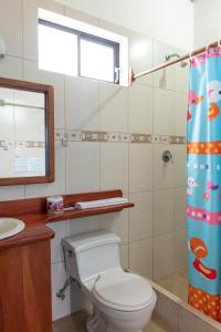 łazienka z toaletą, umywalką i oknem w obiekcie Hotel LA GRAN TORTUGA - ᯤ STARLINK w mieście Puerto Villamil