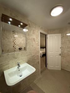 La salle de bains est pourvue d'un lavabo et d'un miroir. dans l'établissement Clifton House Brighton, à Portslade