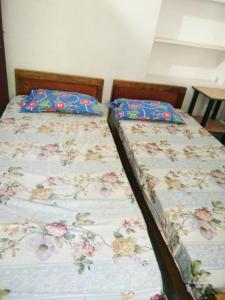 two beds sitting next to each other in a room at Nunu Homestay Guruvayoor in Guruvāyūr