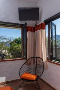 una sedia seduta davanti a una finestra con televisore di Hostal Maria Tepozteca a Tepoztlán