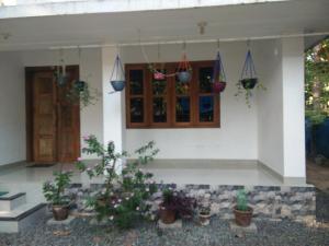 a house with potted plants in front of it at Nunu Homestay Guruvayoor in Guruvāyūr +16 photos