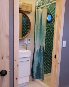 - Baño con cortina de ducha y bosque en Entire Tiny Home close to cruise ship terminal Alaska Railroad and downtown Seward en Seward