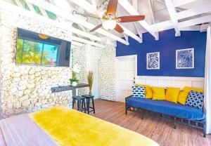 Pool Cottage at Viking Hill - Love Beach في ناسو: غرفة نوم مع أريكة ومروحة سقف