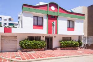 un edificio rojo blanco y verde con garaje en Ayenda 1622 Charmin, en Santa Marta