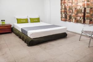 a bedroom with a large bed with green pillows at Ayenda 1622 Charmin in Santa Marta
