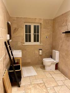 a bathroom with a toilet and a sink at Walnut Tree Cottage Barn in Toppesfield