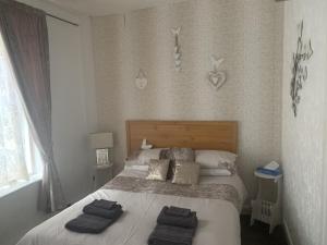 a bedroom with a bed with two towels on it at The Butterfly Hotel in Blackpool