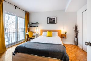 a bedroom with a bed and a large window at Les appartements HOMA in Montreal