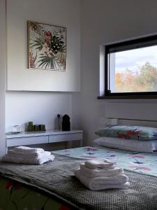 Dos camas en una habitación con toallas. en B&B La Villetta, en Bellante