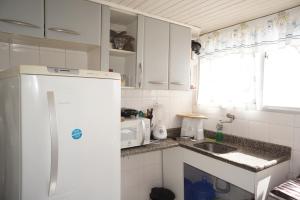 cocina con nevera blanca y fregadero en One-bedroom Apartment with Sea view and View to Farol da Barra Praiaville, en Salvador