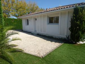 una pequeña casa blanca con un patio de césped en Villa Baïne 8p seignosse en Seignosse