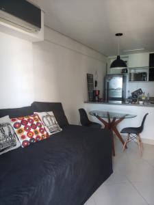 uma sala de estar com um sofá preto e uma mesa em Landscape Diamond 1409 em Fortaleza