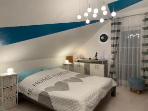 a bedroom with a bed with a blue accent wall at Schlafen in Erfurt- nicht 0815 in Erfurt