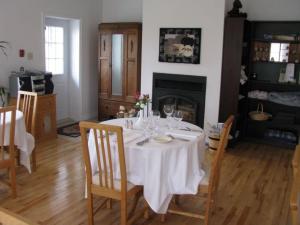 a dining room table with a white table cloth on it at Tulloch Inn & Gifts in Inverness