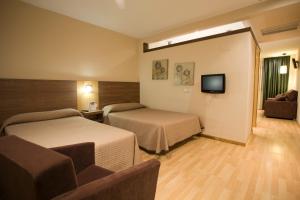 ein Hotelzimmer mit 2 Betten und einem TV in der Unterkunft Hotel Mar de Plata in Sarria