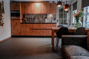 a kitchen with wooden cabinets and a table with chairs at Hoeve Mingels in Banholt