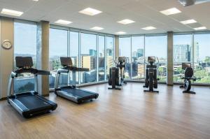 a gym with cardio equipment in a large room with windows at Hyatt House Tempe Phoenix University in Tempe