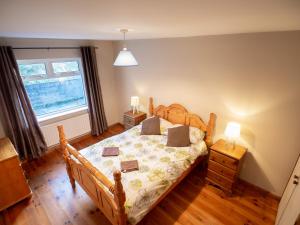 a bedroom with a wooden bed and a window at Sea view cottage in Tully Cross