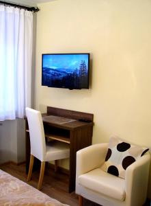 um quarto com uma secretária, uma cadeira e uma televisão em Apartamenty Jagiellonka em Zakopane