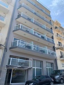 a building with balconies and cars parked in front of it at Vista Point - Cast Renting in Msida