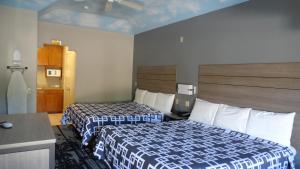 a hotel room with two beds and a desk at Regency Inn and Suites Humble in Humble