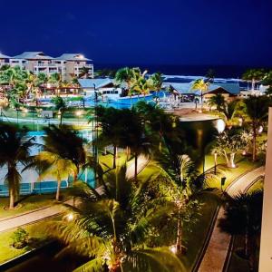 een uitzicht op een resort met palmbomen en de oceaan bij Portamaris Resort Private Apartment 201 in Aquiraz