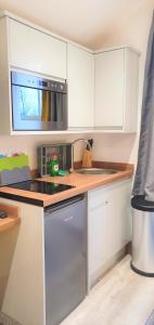 a kitchen with white cabinets and a sink and a microwave at Bath Road Apartments in Swindon