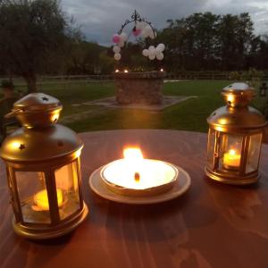 a table with two lanterns and a candle on it at Alloggio Franciscus in Arquà Petrarca