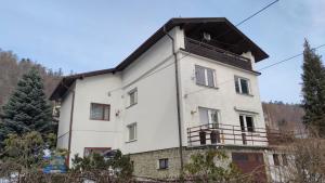 a white house with a balcony on top of it at Alfa 2 apartament 4 in Bystra